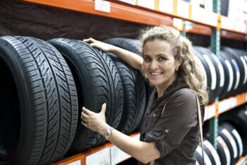 mature smiling caucasian woman shopping for a tire